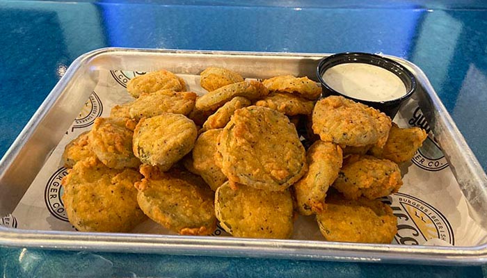 A tray of fried pickles with ranch, perfect with burgers or beer on a blue Florida table.
