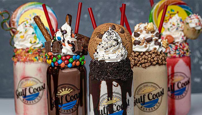 Six colorful, over-the-top milkshakes from Gulf Coast Burger Company in Florida topped with treats.