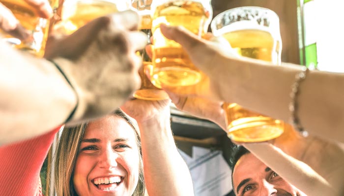 People smiling and raising glasses of beer together in a cheerful Florida toast.