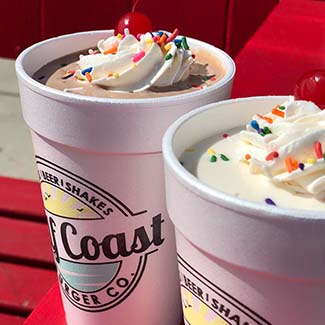 Two milkshakes with whipped cream at Gulf Coast Burger Company on a sunny Florida afternoon.