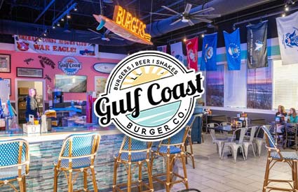 Bar with blue chairs, colorful decor, flags, and Gulf Coast Burger Co. serving burgers and shakes.
