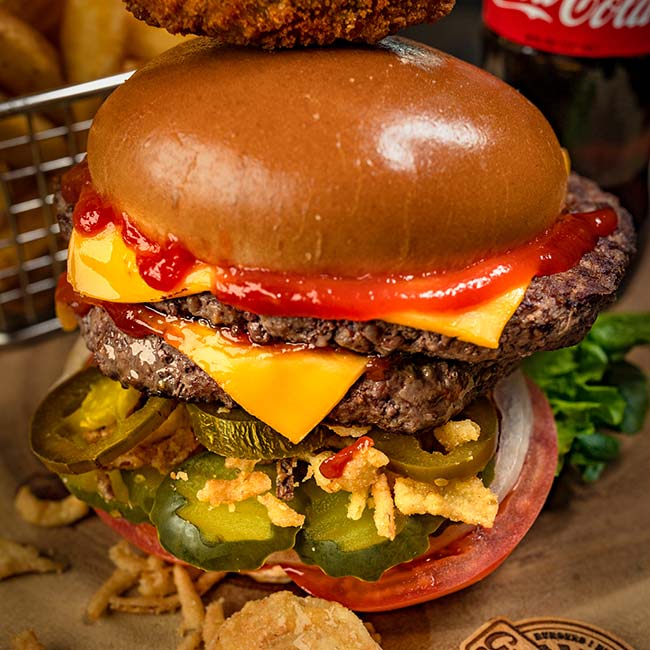 Burgers lovers will enjoy this cheeseburger with ketchup, pickles, jalapeños, and crispy onions.