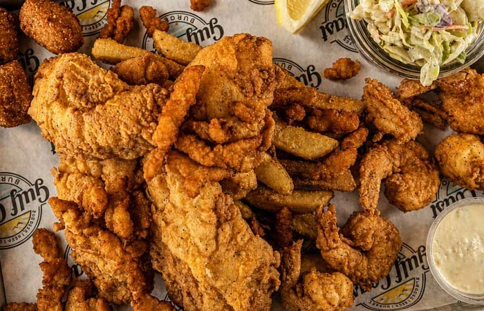 Fried fish, shrimp, fries, hush puppies, coleslaw, and sauce—a true Florida seafood feast.